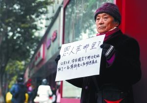 七旬婆婆闹市举牌寻找救夫恩人